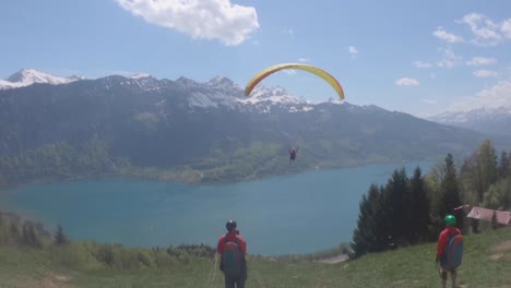 Turistas-En-Parapente-En-Los-Alpes-Suizos-Con-Vistas-A-Una-Hermosa-Vista-De-Las-Montañas---Plano-Amplio