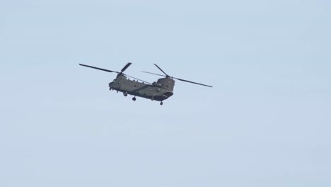 Toma-Ampliada-De-Un-Boeing-Chinook-Volando-En-Cámara-Lenta-Con-Pájaros-Volando-A-Través-Del-Marco