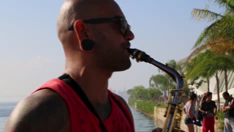 Saxophone-player-playing-with-a-street-band-at-Praca-Maua,-at-sunset,-in-the-center-of-Rio-de-Janeiro,-Brazil