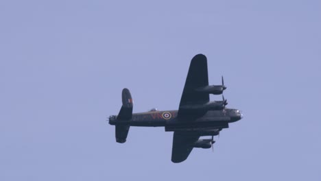 Avro-Lancaster-bomber-plane-flying-in-slow-motion-in-the-sky,-Side-view