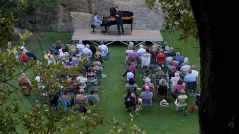 slow-motion-revealing-shot-of-a-pianist-playing-alongside-a-singer-to-an-audience