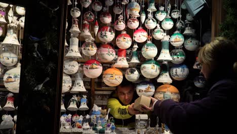 Una-Mujer-Está-Comprando-Adornos-Navideños-De-Madera-Y-Coloridos-En-El-Christkindlmarket-De-Chicago.