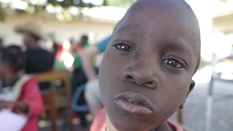 Close-up-young-african-child-smiles-with-joy-among-group-of-friends