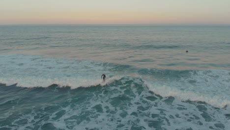 Surfista-Navegando-Por-Las-Tranquilas-Olas-Suaves-De-La-Playa-De-Santinho-En-La-Tarde-De-La-Hora-Dorada