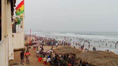 Gründung-Afrikanischer-Menschen,-Die-Sich-Bei-Sonnenuntergang-Am-Sakumono-Strand-Mit-Ghanaischer-Flagge-Versammeln