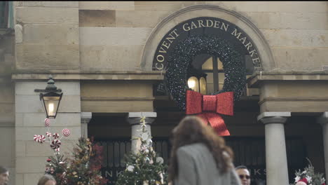 Los-Peatones-Caminan-Por-El-Mercado-De-Covent-Garden-Decorado-Con-Corona-Navideña-Durante-La-Temporada-Navideña