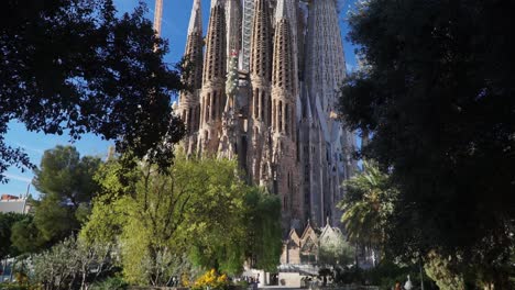 Tilting-UpShot,-revealing-Pathway,-Scenic-view-Sagrada-Familia-Church-in-Barcelona-Spain