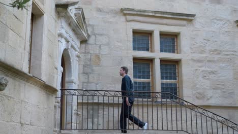 Man-walking-up-the-stairs-of-an-old-stone-building