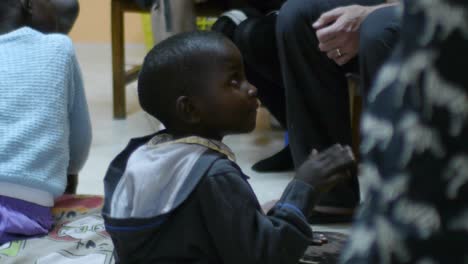 A-joyful-child-with-disabilities-sits-on-the-ground,-banging-a-small-drum-with-enthusiasm