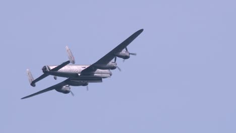 Avro-Lancaster-bomber-in-slo-mo-flying-in-the-blue-sky-in-slow-motion,-rear-view