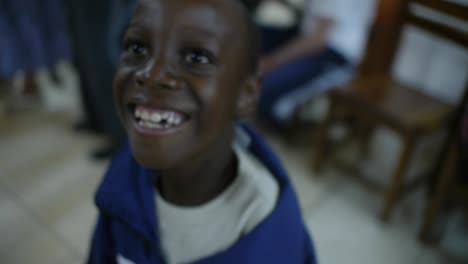 Ein-Kleiner-Junge-In-Einer-Schule-In-Mongu,-Sambia,-Interagiert-Glücklich-Mit-Einem-Kameramann,-Lächelt-Und-Bewegt-Sich-Freudig