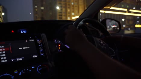 Male-hands-hold-the-steering-wheel-while-driving-a-Toyota-car-on-the-streets-of-HITECH-City,-Close-up-shot