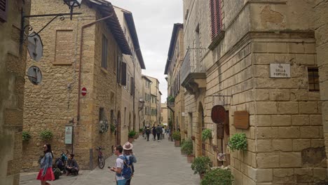 Reisende-Auf-Den-Straßen-Eines-Mittelalterlichen-Dorfes-In-Der-Stadt-Pienza-In-Der-Toskana,-Italien