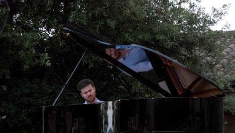 Close-up-shotof-a-man-passionately-playing-the-grand-paino-ourdoors