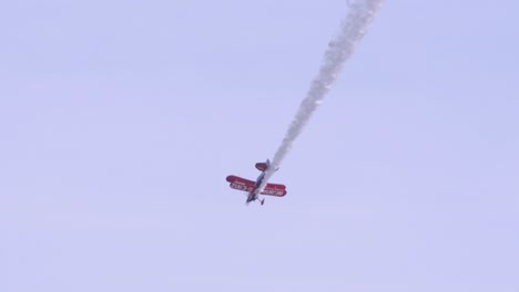 Acrobático-Biplano-De-Músculos-Voladores-Cae-En-Picada-En-El-Cielo-En-Cámara-Lenta,-Rastros-De-Humo-Blanco-Desde-La-Cola