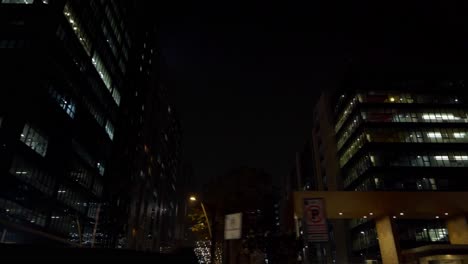 Driver-riding-on-the-roads-of-HITECH-city-of-Hyderabad-with-buildings-and-skyscrapers-illuminated-with-night-light