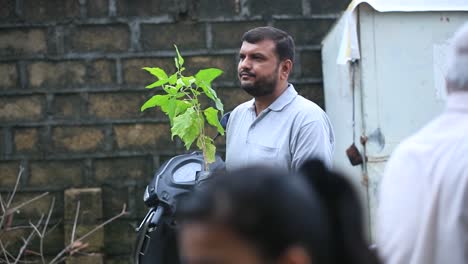 Hombre-Indio-Comprando-Una-Planta-Para-Plantación,-Siga-La-Foto-De-Las-Plantas-Colgando-De-La-Mano-En-El-Mercado