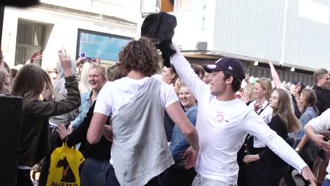 Young-festival-and-party-goers-enjoy-life-at-an-open-air-street-party-dancing-together-united-as-friends