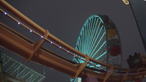 Achterbahn-In-Zeitlupe-Im-Pacific-Park-Am-Santa-Monica-Pier-Mit-Riesenrad-Im-Hintergrund