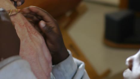 Young-african-boy-plays-with-bracelet-and-wristbands-on-white-forearm