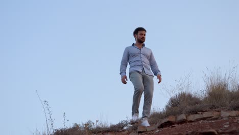 Slowmotion-shot-of-a-man-walking-on-a-trail-during-sunset