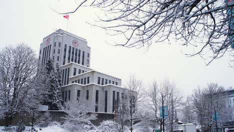 Una-Plataforma-Rodante-De-Derecha-A-Izquierda-Pasó-Junto-A-Los-árboles-Hacia-Un-Ayuntamiento-Nevado-De-Vancouver-Durante-Un-Día-Frío-Y-Nublado