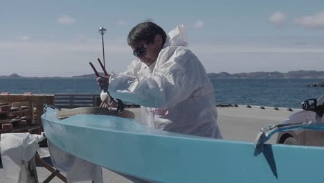 A-local-of-Greenland-making-a-net-by-threading-white-ropes-into-a-steel-frame-using-a-pump-pliers---mid-shot