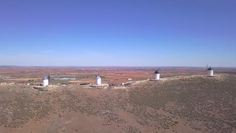 Drone-shot,-truck-right-aerial-view-of-a-serie-of-Windmills-on-the-hill-of-Consuegra