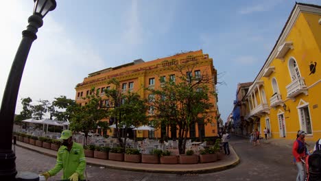 Ein-Mann-In-Einem-Grünen-Anzug-Reinigt-Teile-Eines-Platzes-In-Der-Altstadt-Von-Cartagena-De-Indias,-Kolumbien