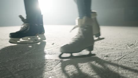 Cámara-Lenta-De-Un-Par-De-Slihouttes-Patinando-Sobre-Hielo-En-Un-Estadio-De-Invierno-Cubierto-De-Nieve