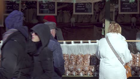 Menschen-Stehen-Davor-Und-Gehen-An-Einem-Weihnachtsstand-Auf-Dem-Weihnachtsmarkt-In-Meran---Meran,-Südtirol,-Italien-Vorbei