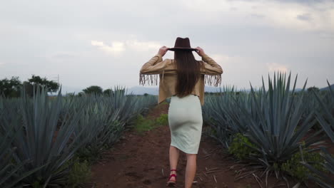 Model-casually-walking-gracefully-posing-with-cowboy-hat---Follow-slow-motion-shot