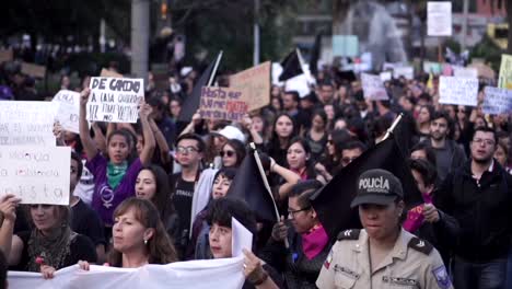 Una-Multitud-De-Mujeres-Y-Hombres,-En-Su-Mayoría-Vestidos-De-Negro,-Marchan-Y-Sostienen-Carteles-Y-Banderas-Negras-Durante-La-Protesta-En-El-Día-Internacional-De-La-Mujer.