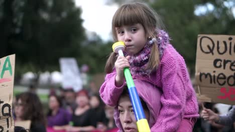 Un-Padre-Lleva-A-Su-Hija-Sobre-Sus-Hombros-Durante-Una-Marcha-Y-Protesta-De-Hombres-Y-Mujeres-En-El-Día-Internacional-De-La-Mujer