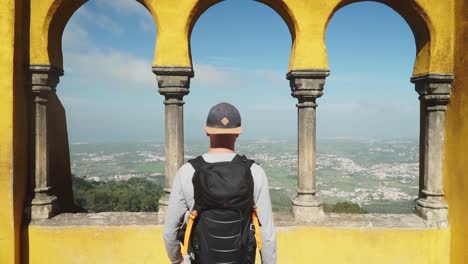 Plano-Medio-De-Un-Camión,-Un-Hombre-Moviéndose-Hacia-La-Plataforma-De-Observación-Entre-Los-Pilares-Del-Palacio-Nacional-De-Pena-En-Portugal