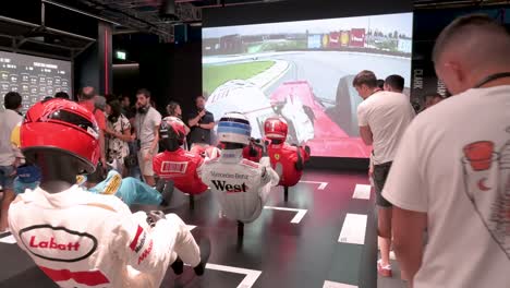 Visitors-look-at-mannequins-dressed-in-racing-suits-highlighting-the-evolution-of-the-F1-sport-and-safety-through-time-during-the-world's-first-official-Formula-1-exhibition