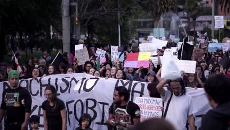 Women-and-men-are-holding-signs-and-big-flags-with-messages-during-a-protest-and-march-on-the-International-Women's-Day