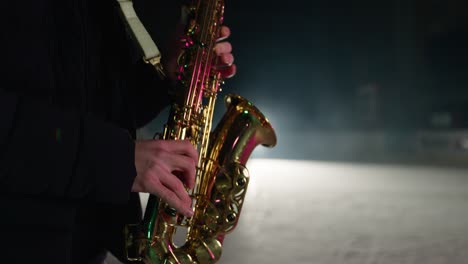 Slowmotion-of-saxophone-player-playing-a-song-on-a-snow-covered-winter-stadium-with-ice-skaters-in-background