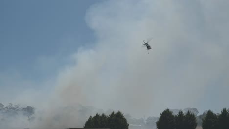 Feuerrettungshubschrauber-Rast-Los,-Um-Grasbrände-Zu-Löschen,-Die-In-Dichten-Rauch-Fliegen