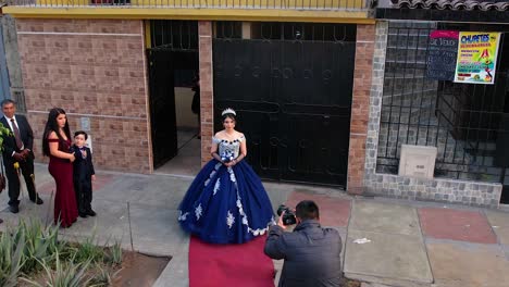 Hombre-Tomando-Fotos-De-Una-Chica-Con-Un-Vestido-Azul-Con-Una-Tiara-Y-Un-Ramo-Antes-De-Una-Fiesta