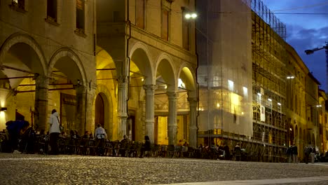 Piazza-Santo-Stefano-Por-La-Noche-Con-Gente-Sentada-Afuera-Junto-Al-Café-Con-La-Madre-Y-El-Niño-Corriendo