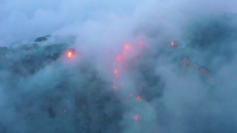 Aerial,-tracking,-drone-shot-of-the-fire-department-using-a-excavator-to-fight-a-wildfire,-smoke-rising,-on-a-dark-blue-evening,-in-Amazon,-Brazil