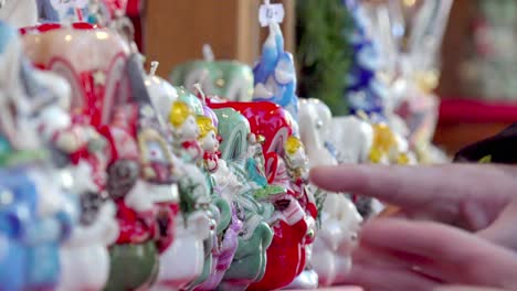 Christmas-candles-being-rearranged-whilst-hands-are-pointing-at-them-at-a-Christmas-stall