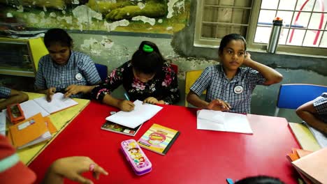 The-camera-pans-forward-showing-the-mentally-retarded-children-doing-their-homework-in-an-NGO-School-of-mental-disorders,-Right-to-Education