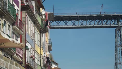 Oben-LKW-Fahren,-Rechte-Aufnahme,-Altstadtgebäude-Gibt-Den-Blick-Auf-Die-Dom-Luis-Brücke-Frei,-Im-Hintergrund-Laufen-Menschen-Auf-Der-Brücke