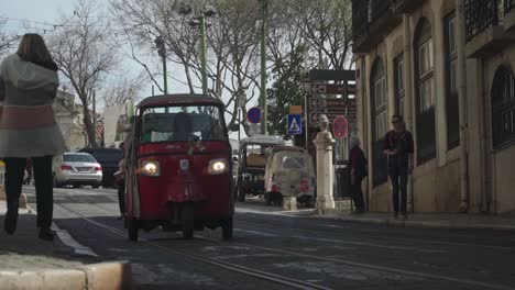 Establishing-shot,-Women-driving-a-Red-Electric-Cart,-People-Walking-around-the-Streets-of-Lisbon-Portugal