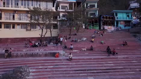 Indian-People-Resting-On-Ghats-Near-River-Ganges-In-Rishikesh,-Uttarakhand,-India