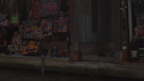 Moving-forward-side-view-shot,-Scenic-view-of-Assorted-Items-in-the-floating-market-in-Thailand,-Tourist-boat-park-on-the-side