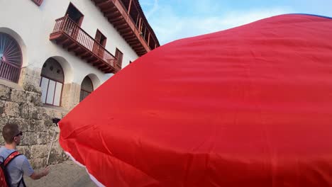 Un-Hombre-Se-Está-Tomando-Una-Selfie-En-Una-Calle-Del-Casco-Antiguo-De-Cartagena-De-Indias,-Colombia,-Mientras-Más-Turistas-Caminan-Frente-A-él