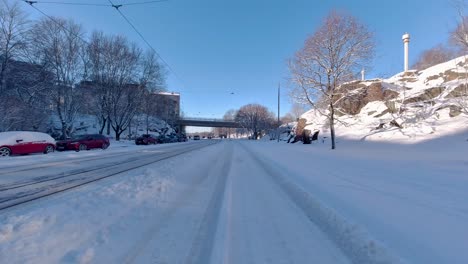 Das-Auto-Fährt-In-Die-Stadt-Ein,-Fährt-Unter-Einer-Brücke-Hindurch-Und-Setzt-Seine-Reise-Inmitten-Der-Stadtlandschaft-Fort